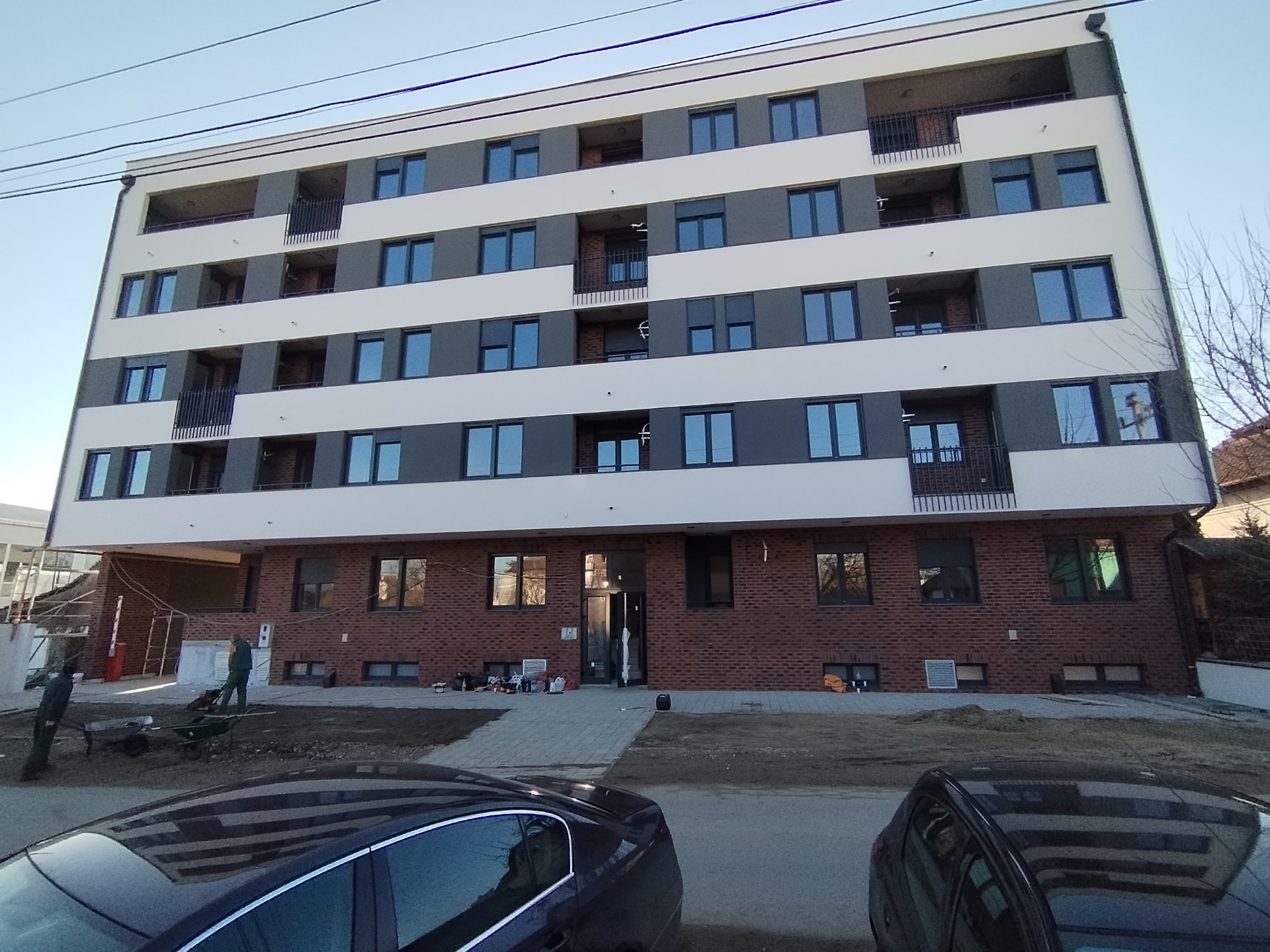 Main entrance of a residential development in Serbia with brick base and glazed lobby door